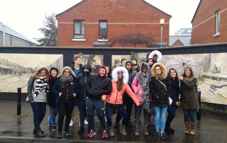 Les lycéens posent devant les premiers murs peints rencontrés à Belfast ce matin.
